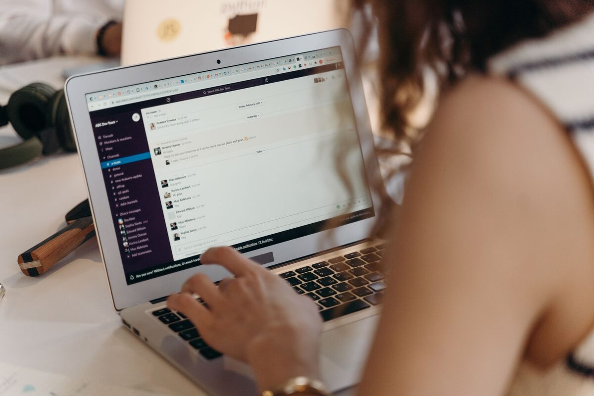Osoba piszącą na klawiaturze laptopa z boku