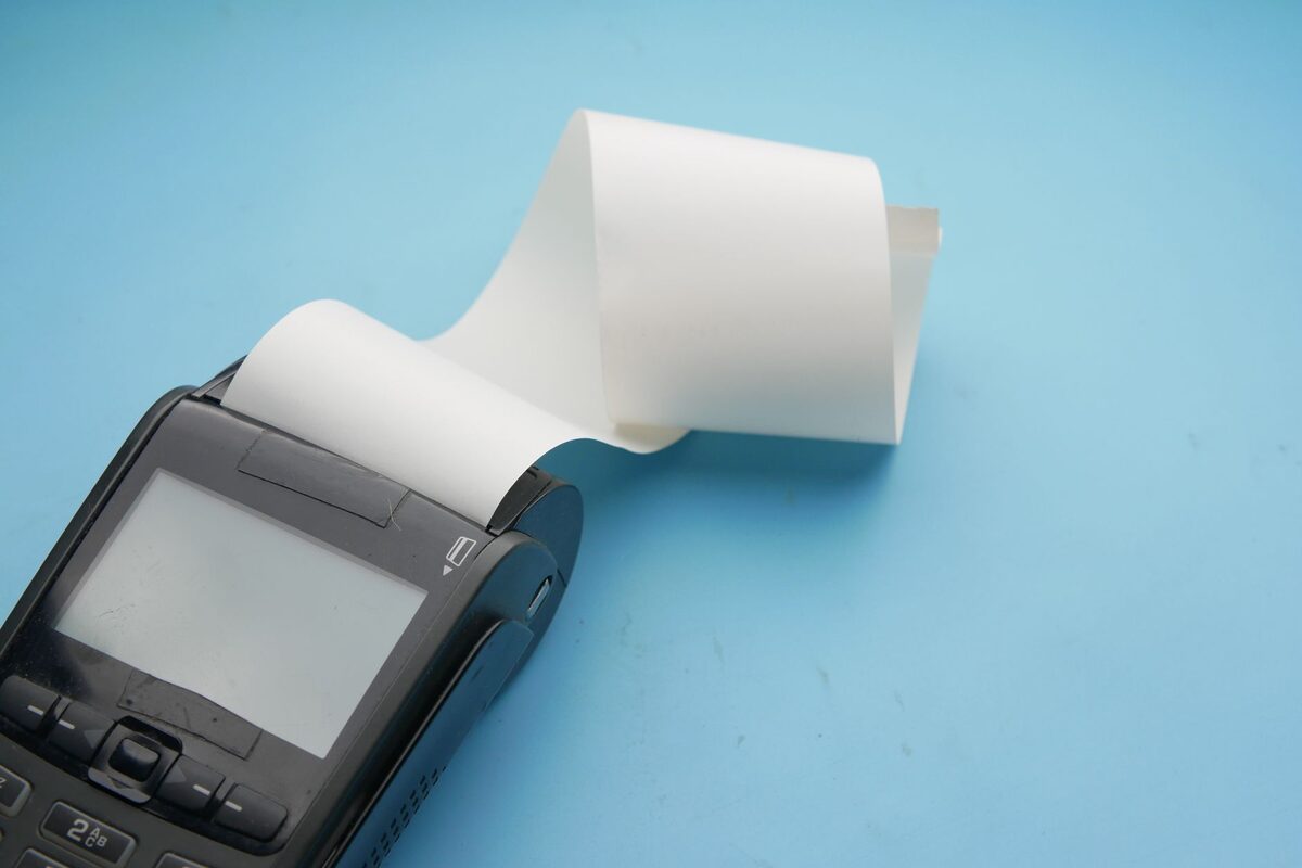 Drukarka fiskalna z rolką papieru na niebieskim tle