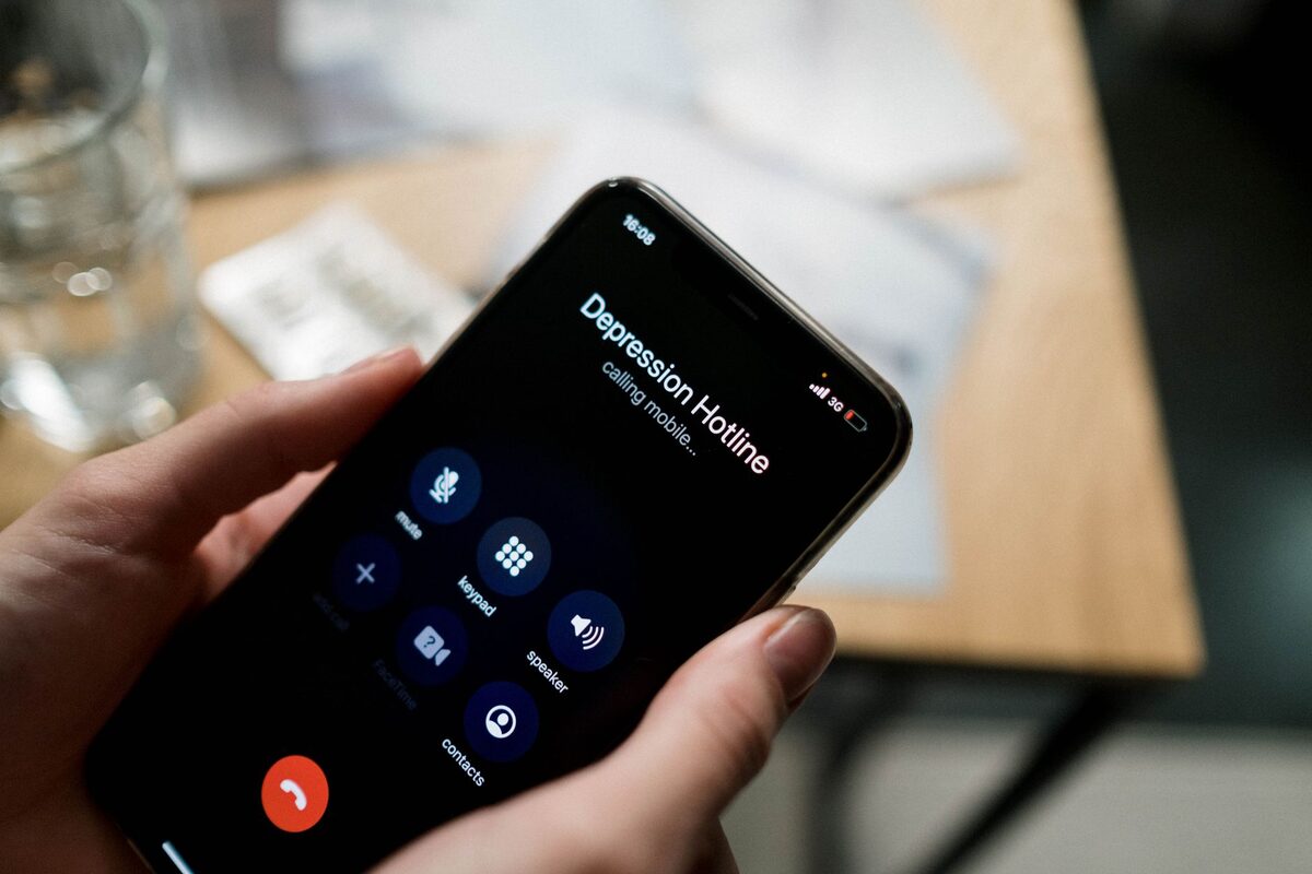 Dłoń trzymająca telefon z ostrzeżeniem o podejrzanej aktywności