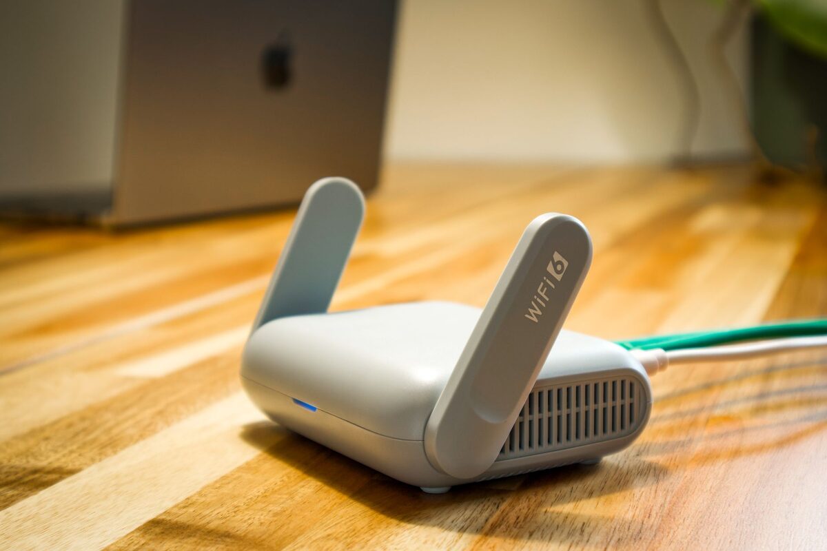 Router internetowy podłączony zielonym kablem na podłodze