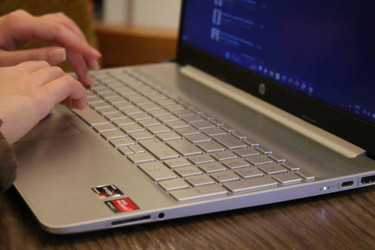 Dłonie piszące na klawiaturze laptopa HP
