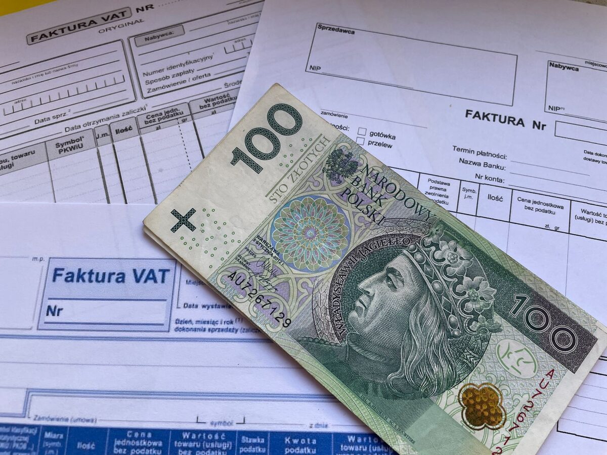 Faktura VAT obok banknotów