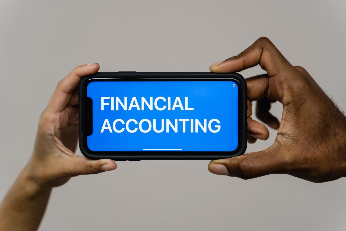 Telefon z napisem Financial Accounting w dłoni