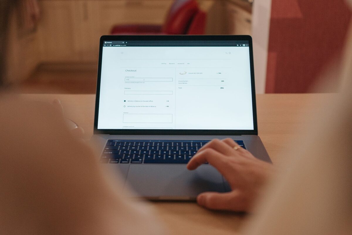 Dłoń przy klawiaturze laptopa z otwartą przeglądarką