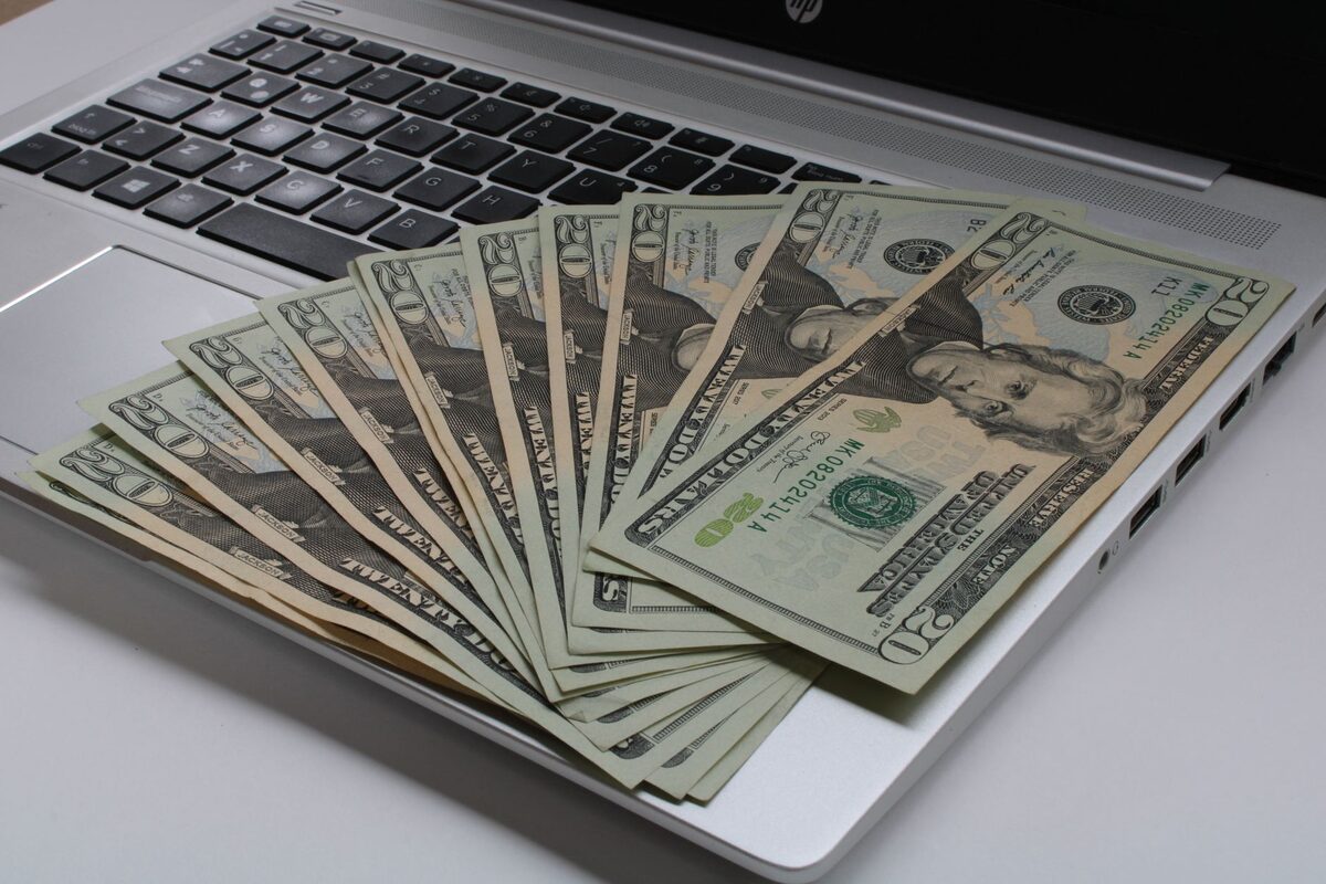 Banknoty ułożone na klawiaturze laptopa